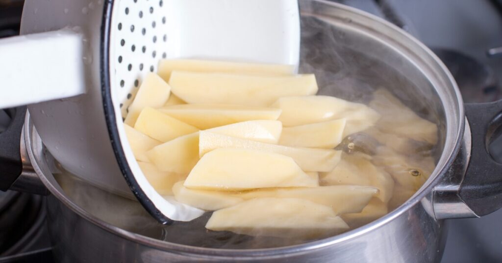 blanching cut potatoes in simmering water