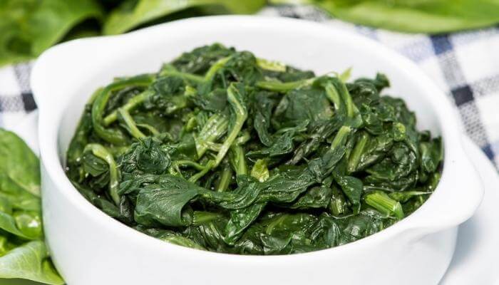 bowl of cooked spinach leaves