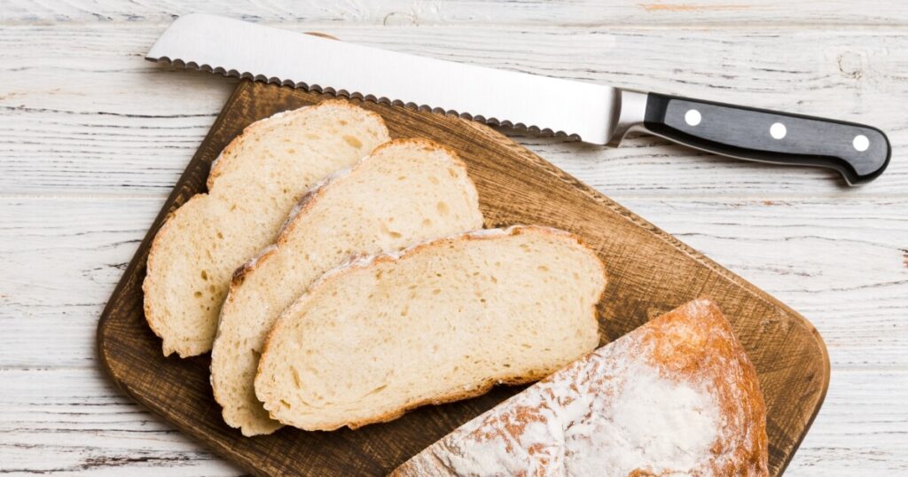 bread knife with sliced loaf on cutting board