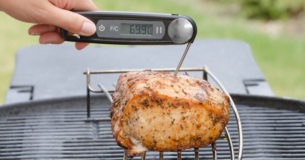 digital thermometer taking temp of pork roast