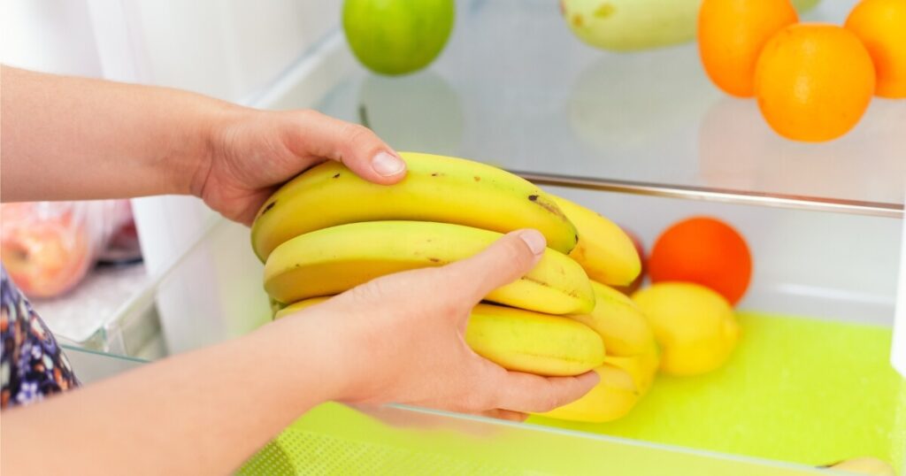 person deciding bananas in fridge