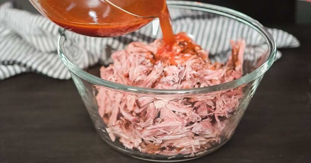 pouring sauce on pulled pork