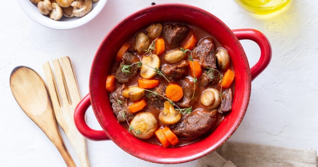 red dutch oven with beef stew