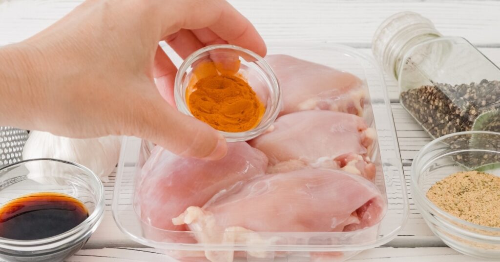 seasoning raw chicken with spices