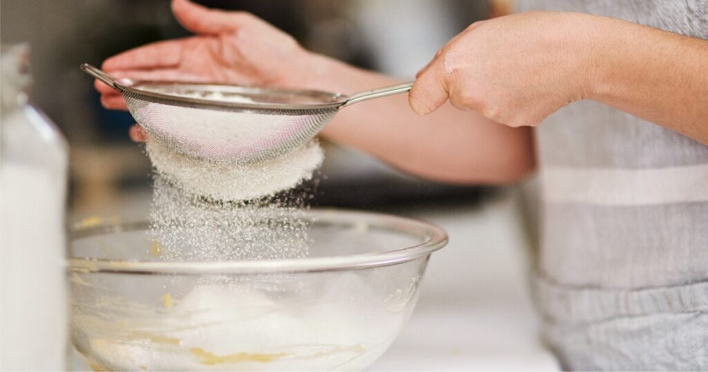 sifting flour into glass bowl