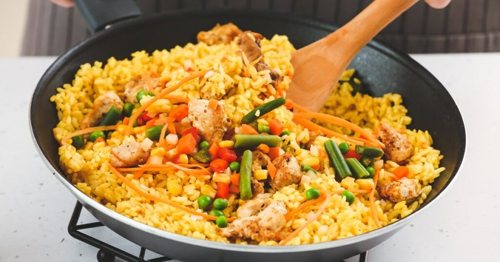 stir frying rice with vegetables and chicken