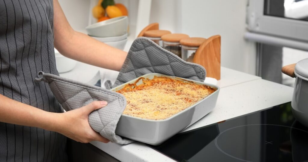 using pot holders to move hot lasagna dish